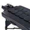 A high-angle close-up of the black upholstery of a professional massage table, featuring a structured grid of integrated airbag modules designed for therapeutic stretching.