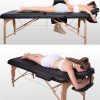 Woman receiving a massage on a black MASTER ETF portable wooden massage table.